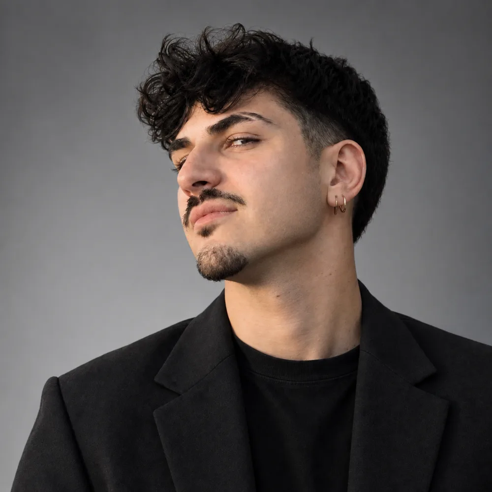 Kevin, in a black jacket against a grey wall